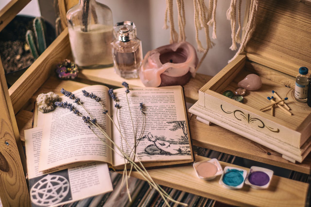 Aesthetic setup with books, lavender, crystals, and candles on a wooden shelf.